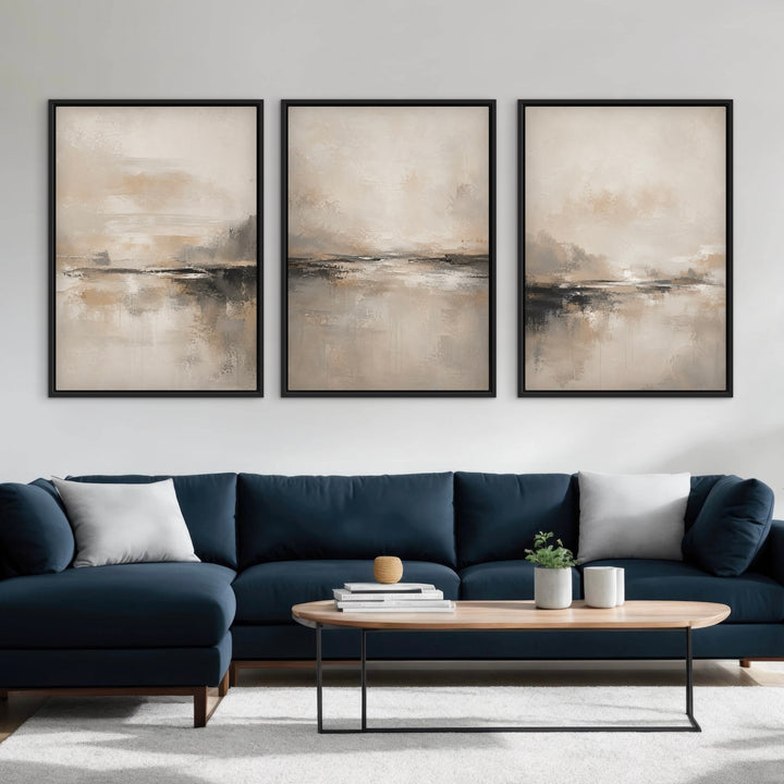 Shoreline set of three neutral abstract framed canvases above a navy sectional sofa