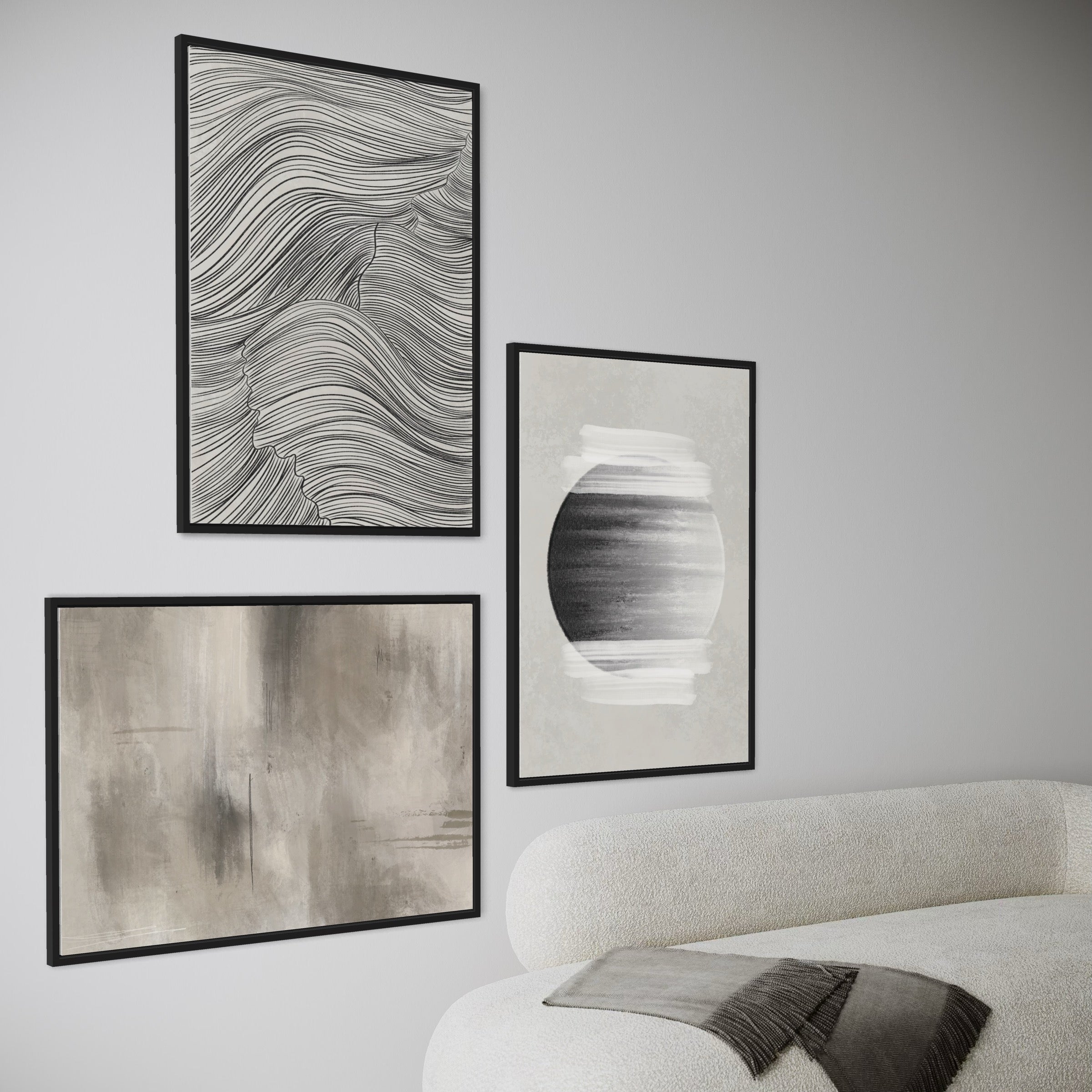 Modern Abstract Wall Art Set Paired with a Cream Boucle Sofa and Charcoal Fringe Throw, Featuring a Black Line-Art Portrait, a Monochrome Circular Brushstroke Piece, and a Warm Taupe Abstract for a Cohesive Neutral Gallery Wall.