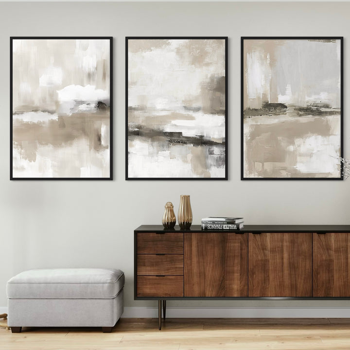 Set of 3 Neutral Abstract Framed Canvas Wall Art Prints Above Mid-Century Wood Sideboard with Decorative Accents and Upholstered Bench