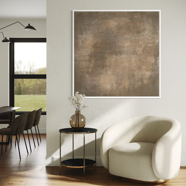 Modern interior with a white armchair, side table, and abstract painting.