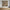 Abstract painting on a wall above a wooden cabinet with decorative items.