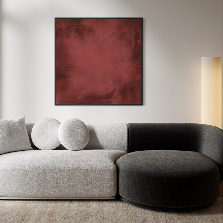 A modern sectional sofa in a minimalist living room, featuring a light beige textured fabric on the left and a dark charcoal gray on the right, with three round throw pillows. A square abstract red painting is mounted on the wall above the sofa.