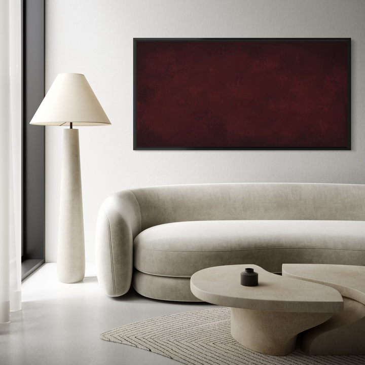 A large rectangular wall art piece with a deep burgundy red textured surface and a thin dark frame, displayed in a modern living room setting above a light beige sofa.