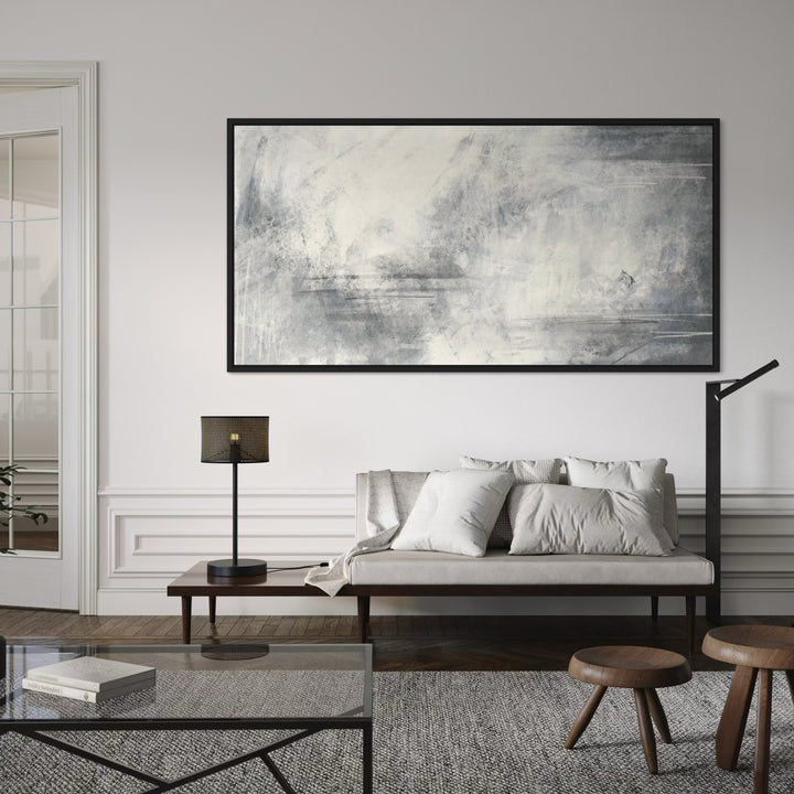 Large Abstract Framed Canvas Above a Neutral Settee with Glass Table, Black Lamps, and Walnut Stools—Elevate a Refined Living Room With Panoramic Wall Art.