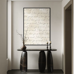 Cream Love-Quote Canvas Above a Sculptural Black Marble Console With Branches and Candlesticks, Elevate Your Entryway with Minimalist, Modern Wall Art.
