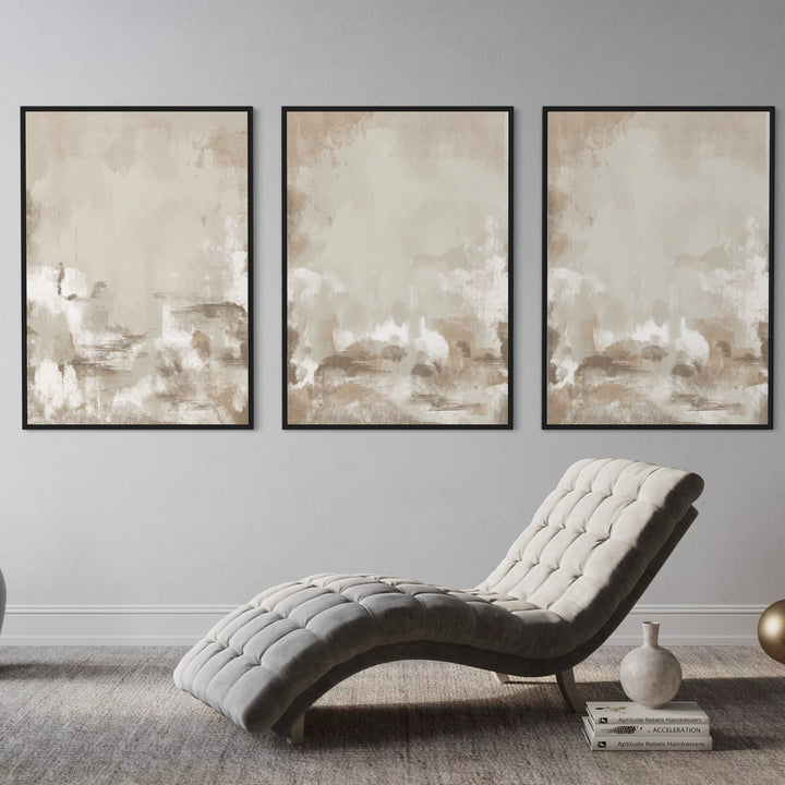 Neutral Beige Abstract Triptych Above a Tufted Grey Chaise With Books, Ceramic Vase, and Brass Orb—Serene Wall Art to Elevate a Modern Reading Corner.