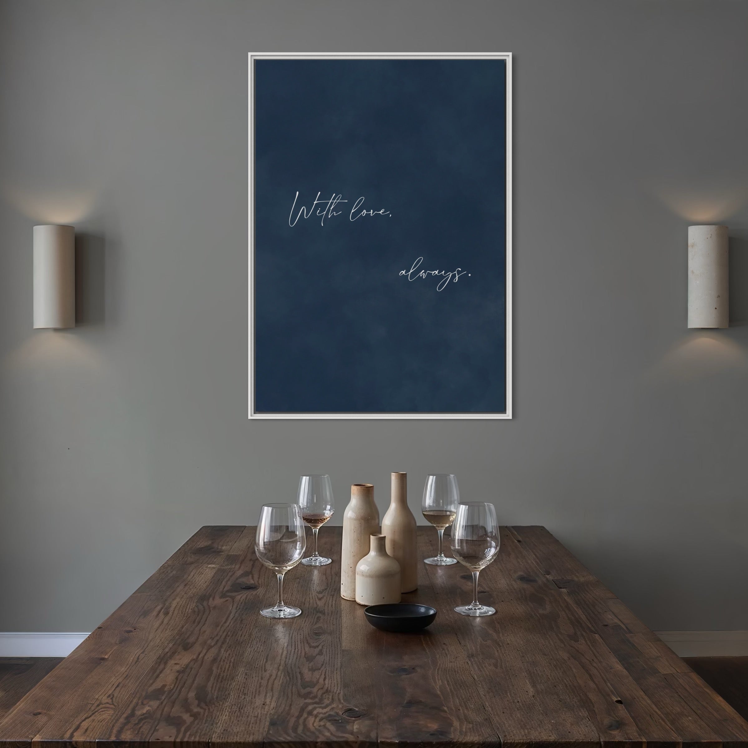 White-Framed Navy Quote Canvas—“With love, always.”—Styled With a Rustic Wood Dining Table, Stoneware Vases, and Wall Sconces For a Cozy Modern Dining Room.