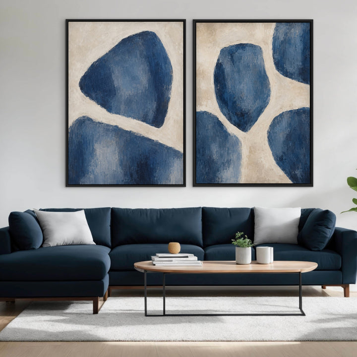 Bleu Forms set of two organic blue abstract framed canvases above a navy sofa