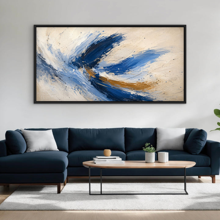 Cobalt Flight blue and gold panoramic abstract framed canvas above a navy sofa