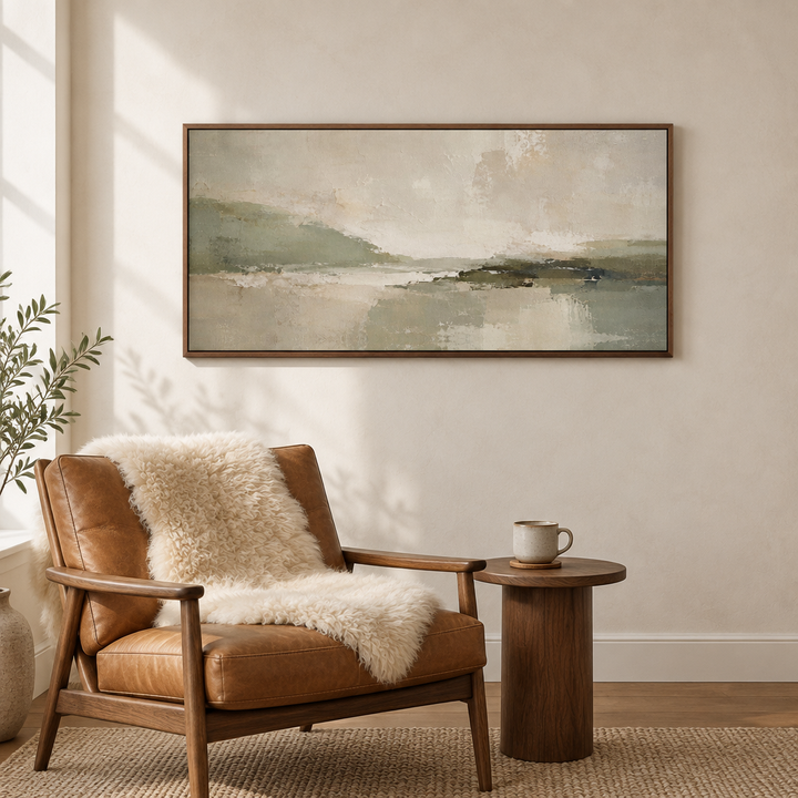 Green Essence sage green panoramic framed canvas in a brown wooden frame above a tan leather lounge chair