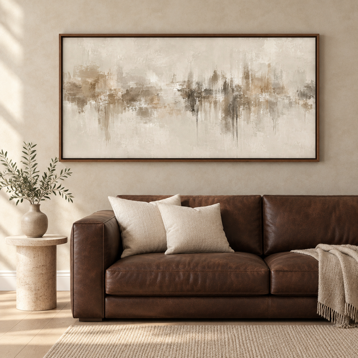Neutral Depths panoramic abstract framed canvas in a brown wooden frame above a chocolate leather sofa