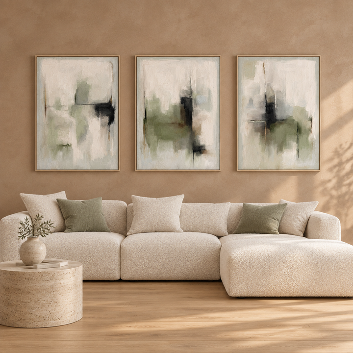 Tuscany Green set of three sage framed canvases in natural oak frames above a cream boucle sectional sofa